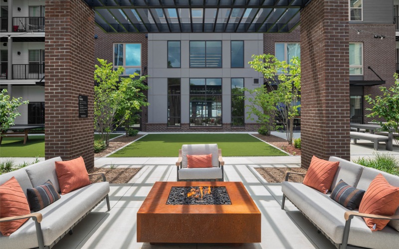 a patio with chairs and tables and a building in the background