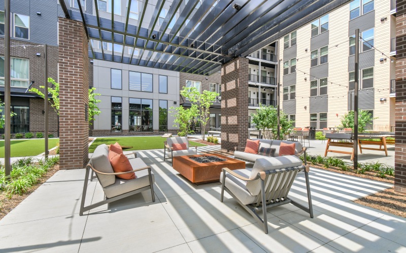 a courtyard with a few chairs and a covered patio